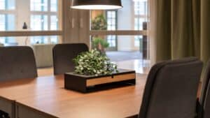 Fyra tygklädda kontorsstolar runt ett fyrkantigt bord.