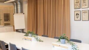 Konferensrum med många stolar runt ett långt bord.