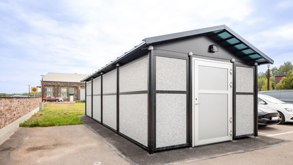 En vit och svart byggnad som står på en parkeringsplats.