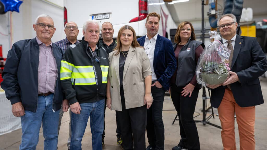 En grupp människor står framför en buss.