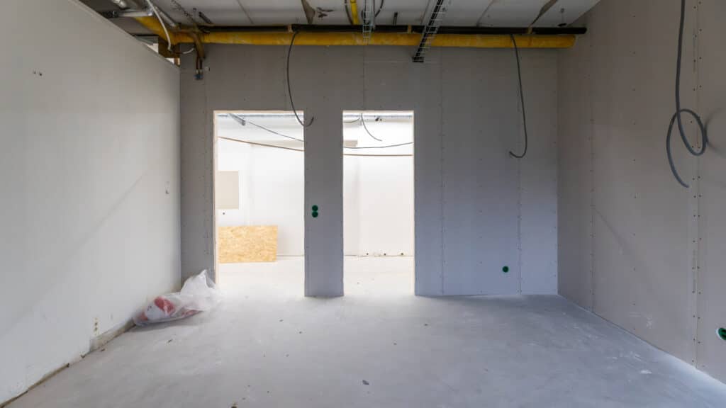 Ett tomt rum med två hål i väggen där dörrar ska sättas in.