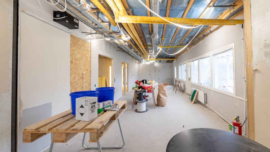 Ett stort rum med många lådor och verktyg på golvet.